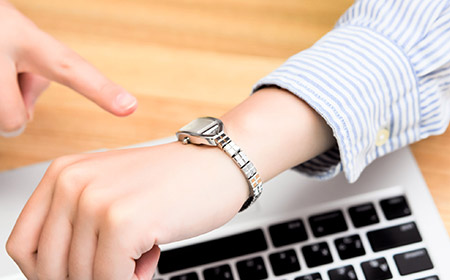 腕時計で時間を確認する女性