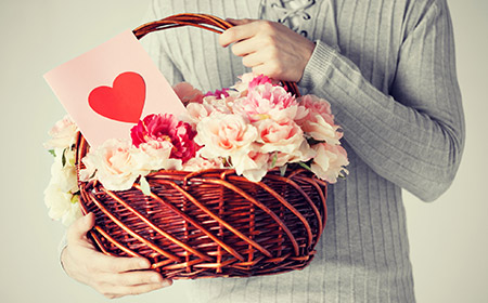 バスケットに入った花を持つ男性